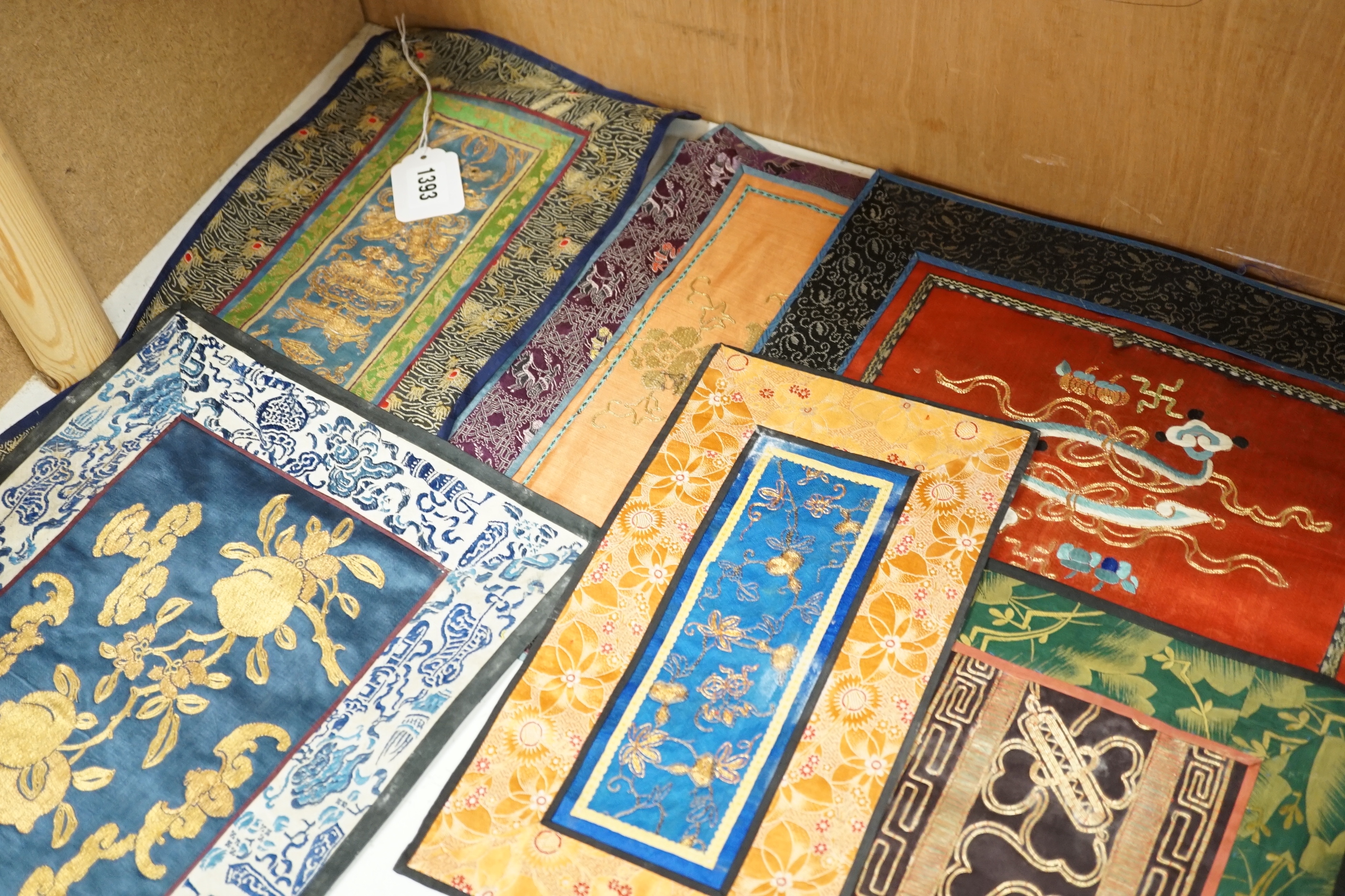 Nine Chinese silk embroidered panels, embroidered with gold thread and bordered with silk damask and brocade